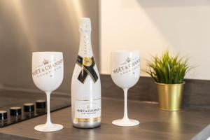 a bottle of champagne and two wine glasses on a table at Luxury Selly Oak Apartment near QE & Uni - Secure Parking - 20CC in Birmingham