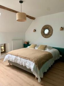 ein Schlafzimmer mit einem großen Bett und einem Spiegel in der Unterkunft La MIDAD in La Chapelle-Thècle