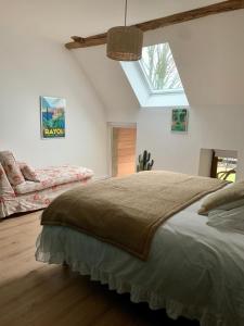 ein Schlafzimmer mit einem großen Bett und einem Dachfenster in der Unterkunft La MIDAD in La Chapelle-Thècle
