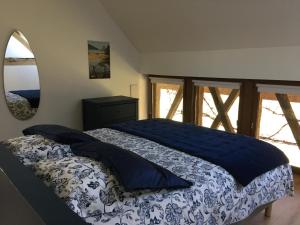 Schlafzimmer mit einem Bett mit blauer Decke in der Unterkunft La MIDAD in La Chapelle-Thècle