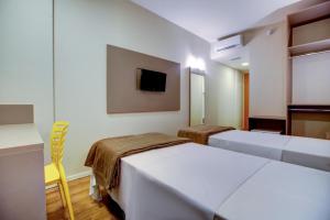 una habitación de hotel con dos camas y un televisor en Blue Tree Towers Sorriso, en Sorriso