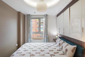 a small bedroom with a bed and a window at 5-Star Kings Cross Home with Gym - Central London in London