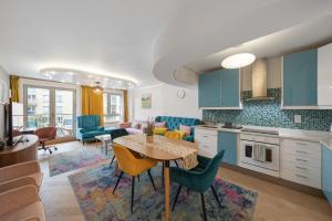 a kitchen and living room with a table and chairs at 5-Star Kings Cross Home with Gym - Central London in London