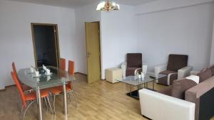 una sala de estar con una mesa y un sofá en Central Apartament Predeal Nr 5, en Predeal
