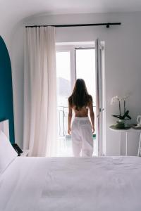 a woman is looking out of a window at Miramare Sea Resort & Spa in Ischia