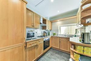 a large kitchen with wooden cabinets and a window at Newly Furnished Penthouse Mayfair in London