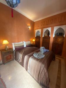 a bedroom with two beds with a towel on them at Riad Dar Teranga Hotel & Spa in Marrakesh