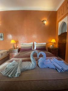 two swans laying on top of a bed at Riad Dar Teranga Hotel & Spa in Marrakech