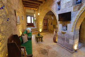 a large room with a stone wall with a living room at Bedrock Cave Hotel in Göreme