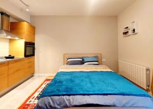 um quarto com uma cama grande e uma cozinha em Lovely Studio Apartment in M3 Saburtalo-District. em Tbilisi