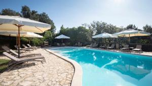 una piscina con ombrelloni e sedie a sdraio e una piscina di Tenuta il Sassone - Wine&Food a Massa Marittima