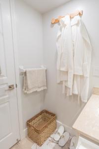 a bathroom with a rack with white clothes and shoes at Boutique Suite in Downtown Toronto, Free Parking! in Toronto