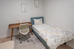 a bedroom with a bed and a desk and a chair at Boutique Suite in Downtown Toronto, Free Parking! in Toronto