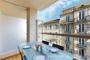 a table on a balcony with a view of a building at Suite Aquarius FSHH in Nice