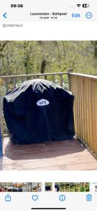 Creekside Lodge Bathpool Launceston Cornwall في لاونسستون: خيمة سوداء جالسة على سطح خشبي
