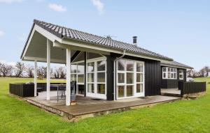 ノーポにあるNice Home In Nordborg With 3 Bedrooms, Sauna And Wifiのデッキと大きな窓が備わる家