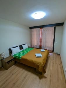 um quarto com uma cama com um edredão verde em Business and Leisure apartments in Mladost 2 with FREE Garage em Sófia