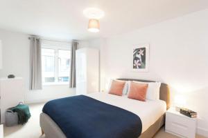 Newly Furnished Penthouse Mayfair في لندن: غرفة نوم بسرير كبير في غرفة بيضاء