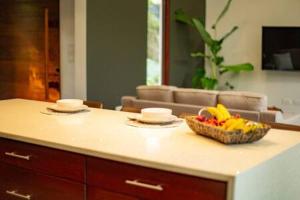 a kitchen with a bowl of fruit on a counter at Private Modern Villa Near Resort District in Benque Viejo del Carmen