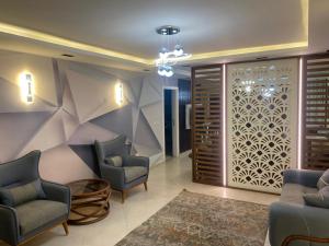 vestíbulo con 2 sillas y sala de espera en Hotel apartment for rent Mohandsen en El Cairo
