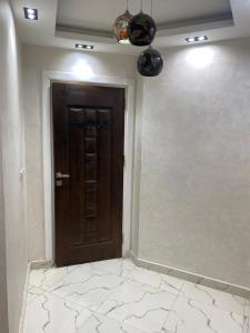 Una puerta de madera en una habitación con suelo de baldosa. en Hotel apartment for rent Mohandsen en El Cairo