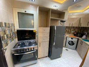 a kitchen with a stove and a refrigerator at Hotel apartment for rent Mohandsen in Cairo