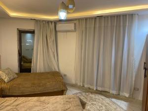 a bedroom with two beds and a window with curtains at Hotel apartment for rent Mohandsen in Cairo