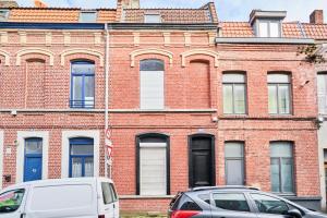 two cars parked in front of a brick building at NG SuiteHome - Lille l Roubaix Barbieux l Miln - Netflix - Wifi in Roubaix