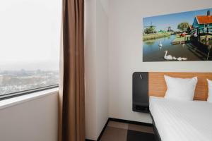 a hotel room with a bed and a window at easyHotel Amsterdam Zaandam in Zaandam