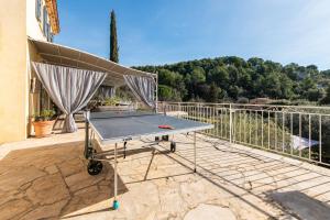 a ping pong table sitting on a patio at Le Chemin de la Grave - Maison avec piscine in Aups