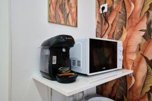 a coffee maker and a microwave on a shelf at NG SuiteHome - Lille l Roubaix Barbieux l Miln - Netflix - Wifi in Roubaix