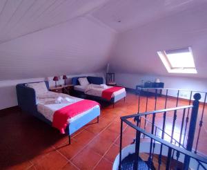 a attic room with two beds and a couch at Casas da Biquinha in Sintra