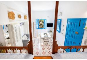 Pokój z dwoma niebieskimi drzwiami i stołem w obiekcie Avlona Blue w mieście Diafani