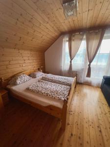 Cama grande en habitación de madera con ventana en Mentebauer Traudi's Ferienhof, en Rothenthurn