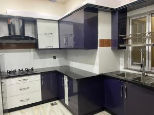 una cocina con armarios morados y blancos y fregadero en BAHRIA HOLLIDAY HOME, en Rawalpindi