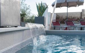uma fonte numa piscina com cadeiras e um guarda-sol em Dependance Villa Sassolini em Montevarchi