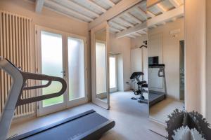 Habitación con gimnasio con cinta de correr y espejo en Dependance Villa Sassolini en Montevarchi
