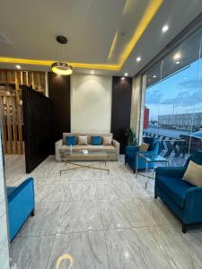 a living room with a couch and blue chairs at رواح للشقق المخدومة- الحوية in Al Muraysīyah