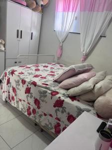 1 dormitorio con 1 cama con edredón y almohadas de flores en Ótimo apartamento en Porto Seguro
