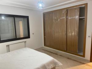 ein Schlafzimmer mit einem Bett und einem großen Fenster in der Unterkunft Appartement jardin de Carthage tunisia in Tunis