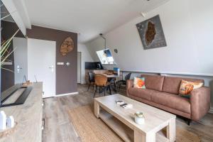 a living room with a couch and a table at Anna 222 in De Koog