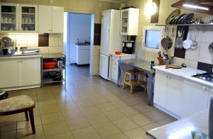 a large kitchen with white cabinets and a tile floor at Pensiunea Tiuta in Corbeni