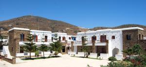 a building with a mountain in the background at Tinos Suites & Apartments with sea view in Agios Ioannis Tinos