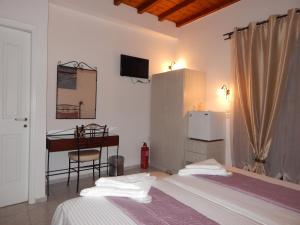 a bedroom with a bed and a desk and a table at Tinos Suites & Apartments with sea view in Agios Ioannis Tinos