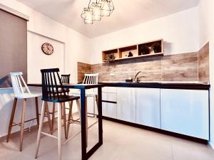 a kitchen with a table and chairs and a sink at ITHACA Σπίτι με αυτόνομη είσοδο in Thessaloniki