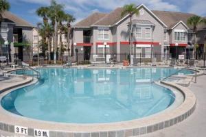 a large blue swimming pool in front of a building at Apartment for 6 very close to Disney in Orlando
