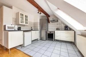an attic kitchen with white cabinets and appliances at Monteurzimmer in Bad Bodenteich