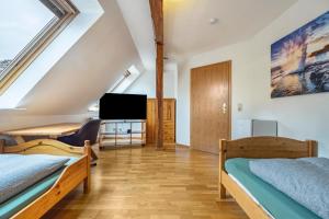 a attic bedroom with two beds and a tv at Monteurzimmer in Bad Bodenteich