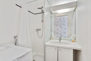 y baño blanco con lavabo y ducha. en 247 Suite Milan - Superb apartment in Paris. en París