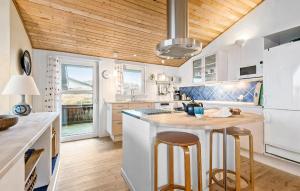 una cocina con electrodomésticos blancos y techos de madera. en Pallas, en Fanø